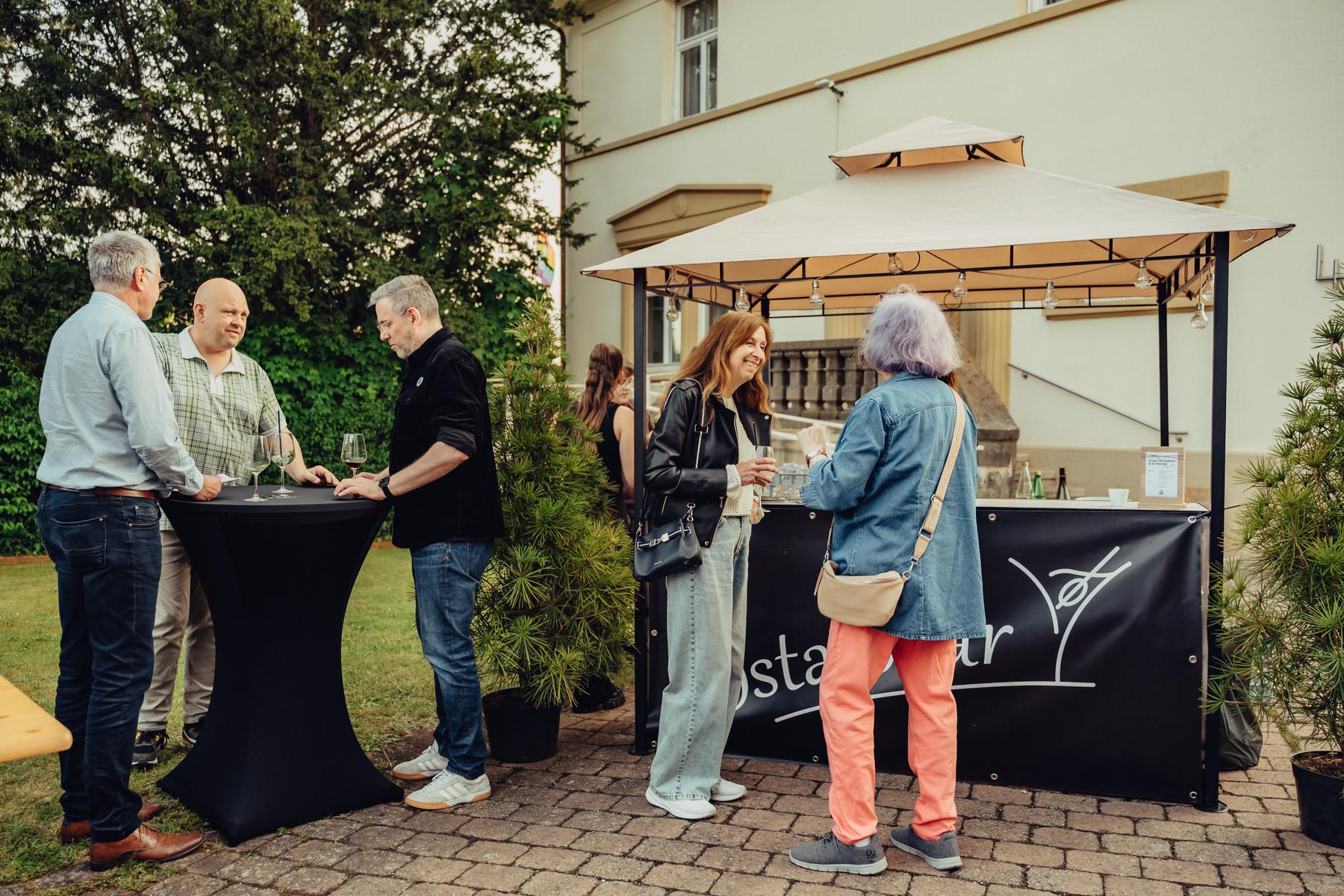 Die Ostalbbar mit Gästen vor einer Villa