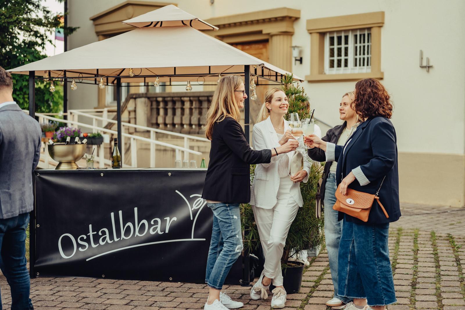 Gäste stoßen mit Cocktails an der mobilen Ostalbbar mit Pavillon an